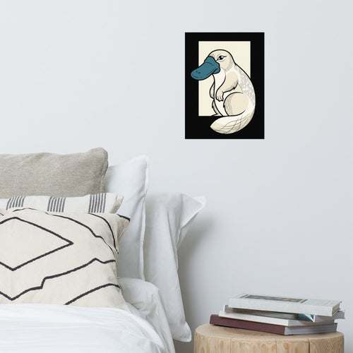 Affiche illustration ornithorynque 30x40 en line art géométrique, bec bleu pétrole et corps crème sur fond noir encre, posée contre un mur clair dans une pièce à la déco moderne